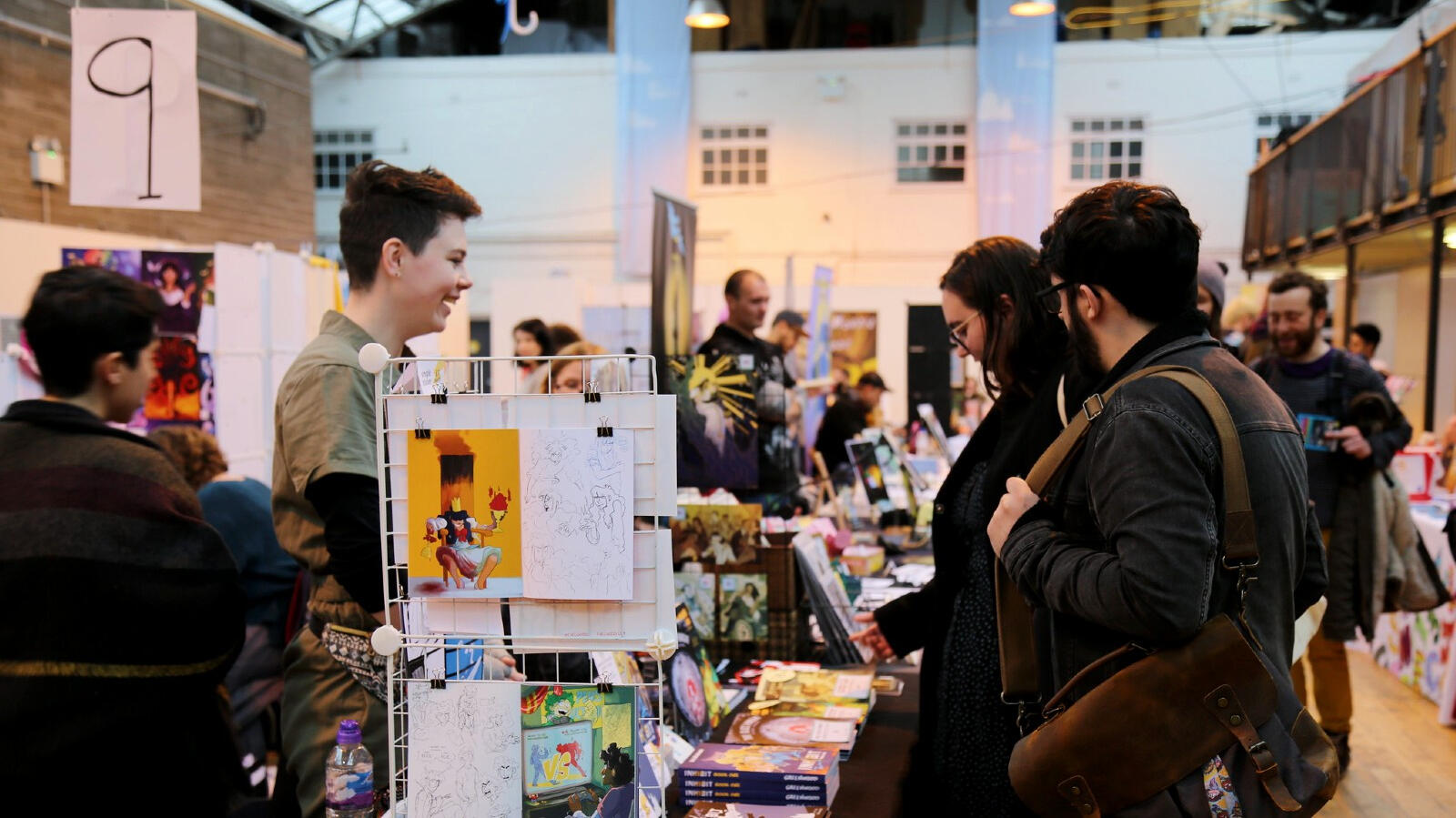 Close up photo of warmly dressed visitors chatting with a stall vendor. Close up photo of warmly dressed visitors chatting with a stall vendor.