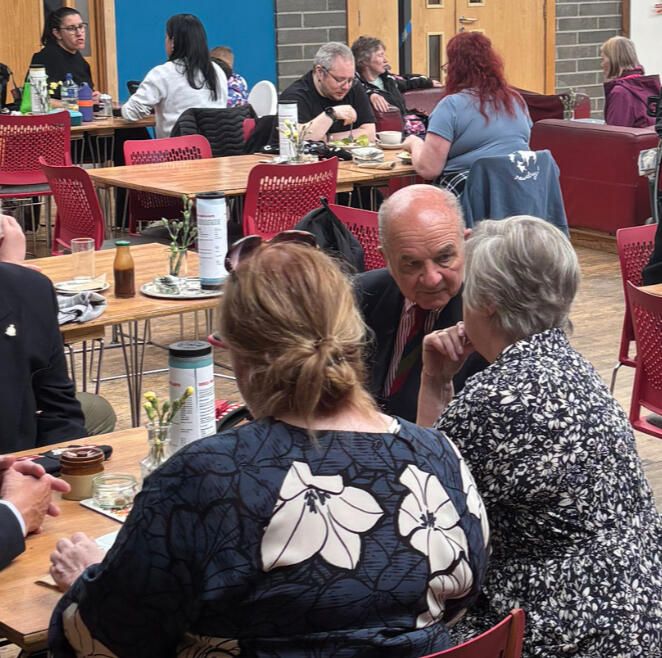 Photo of the Drill Hall Cafe, with people sitting drinking coffee and chatting.